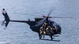 Helicopter with four soldiers flies over water