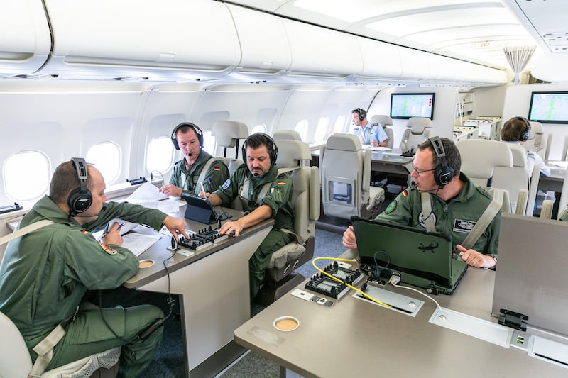 military personnel onboard an a319 modified for special missions.