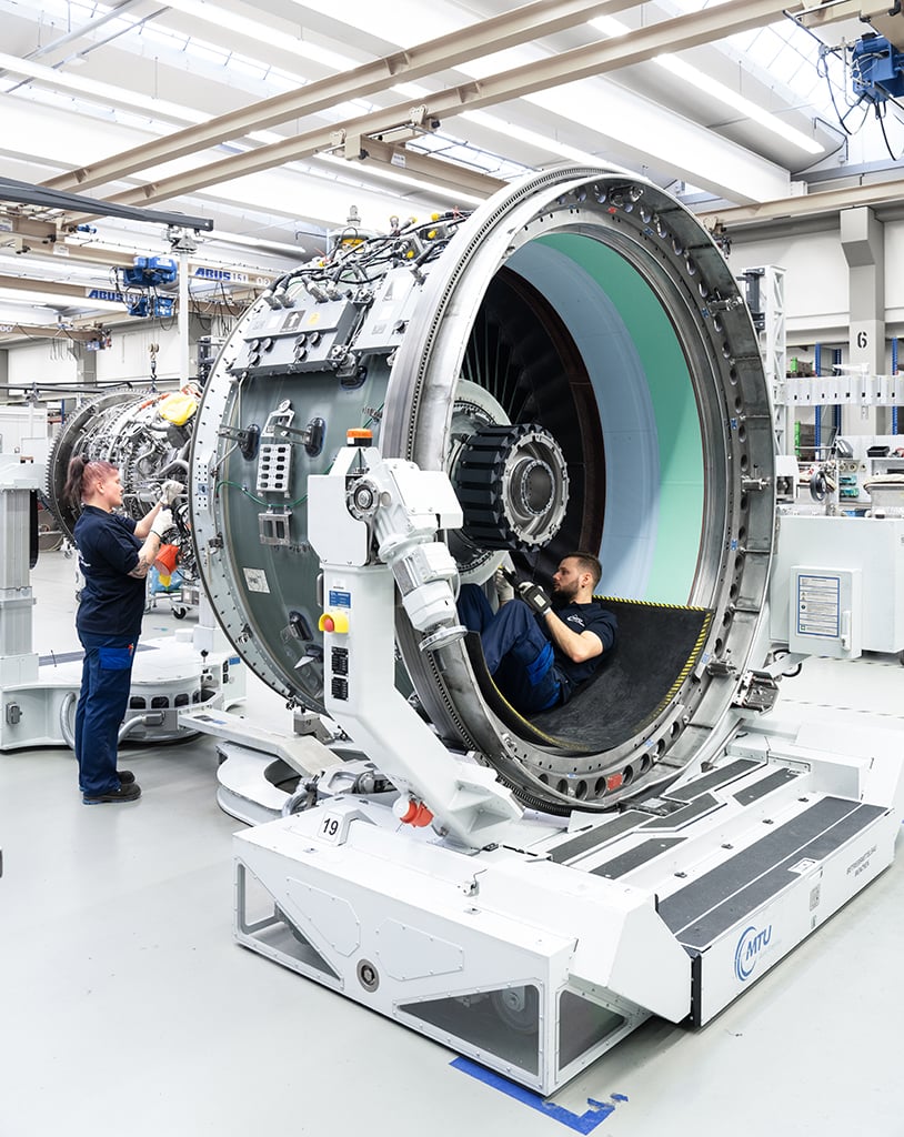 Technicians assembling a Pratt & Whitney PW1100G engine