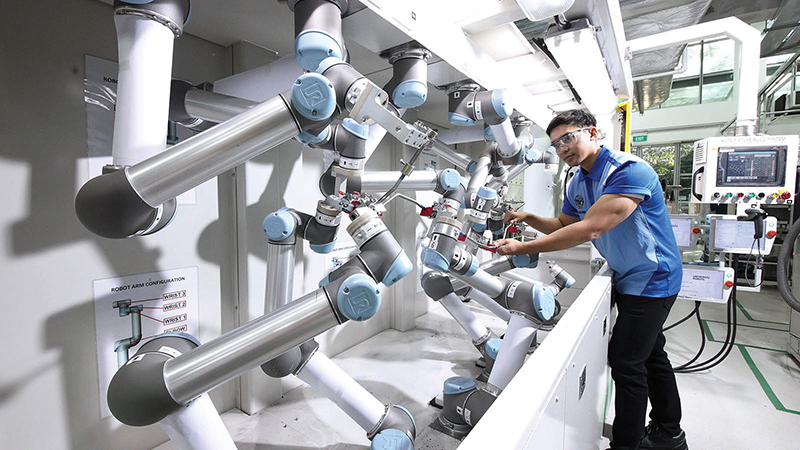 Pratt & Whitney employee working on robotic arms