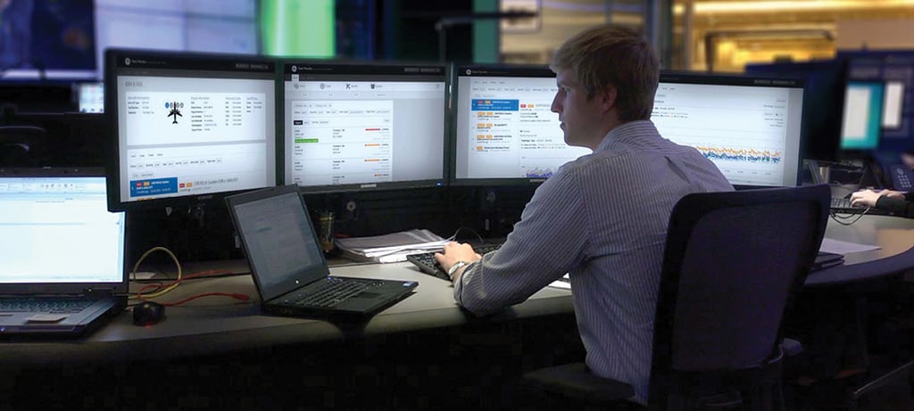 man sitting at computer monitors