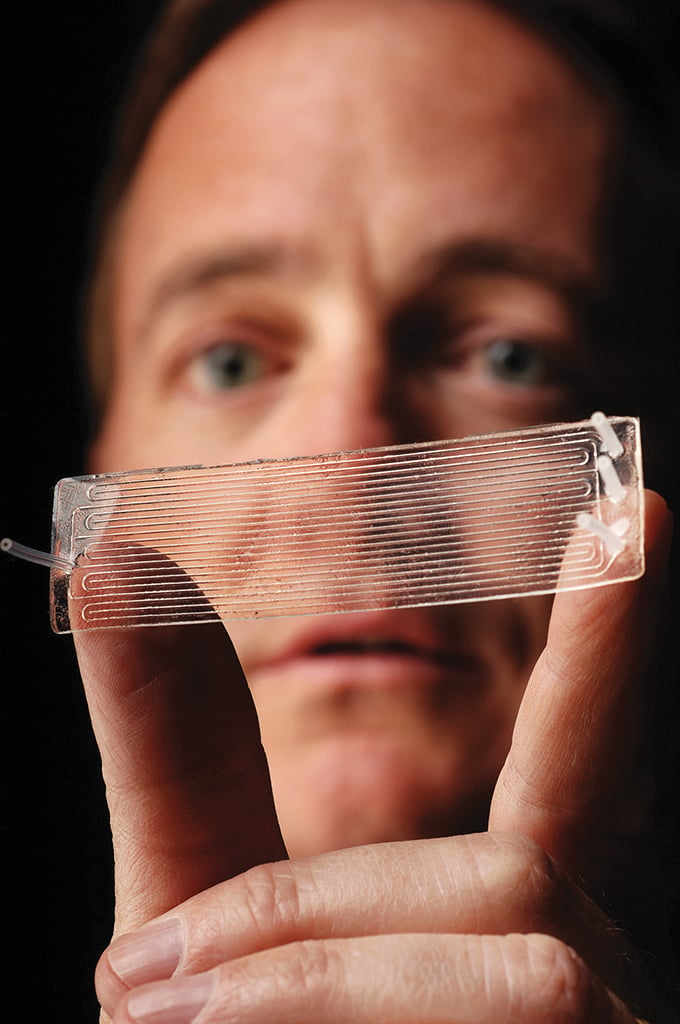 Man holding transparent CVM device between fingers