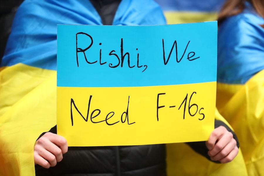 A fan of Ukraine holding a ukraine flag with a message on saying Rishi we need f-16s during the UEFA EURO 2024 qualifying round group C match between England and Ukraine