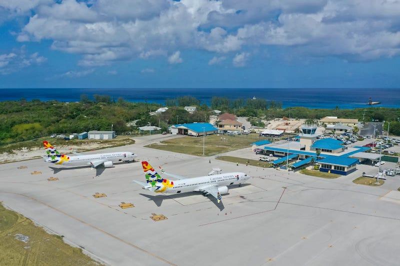cayman airways jets at airport by beach