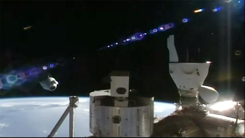 The SpaceX Dragon Freedom spacecraft (left) backs away from the space station carrying four Axiom Mission 3 astronauts