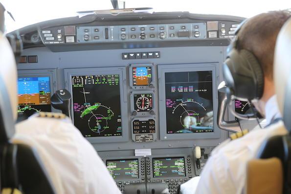 business aviation cockpit pictured over the shoulders of two pilots