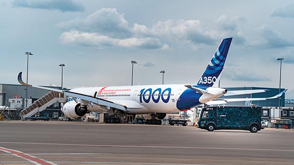 Truck parked in front of Airbus A350 on runway