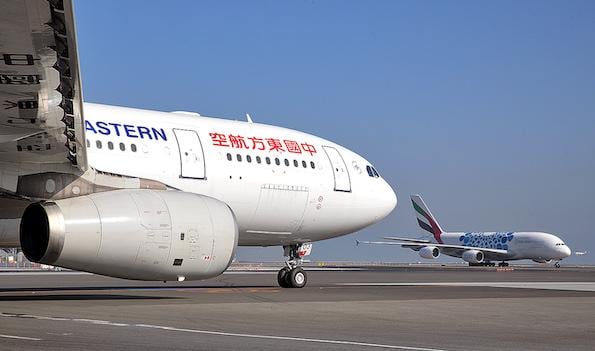 china eastern airlines widebody aircraft foreground on tarmac and emirates airline widebody in background taxiing