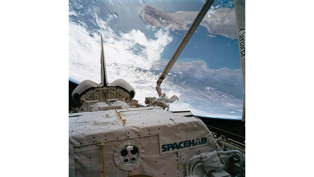spacehab module on space shuttle endeavor docked at the ISS and two astronauts doing an eva