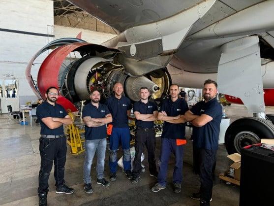 Technicians in front of engine
