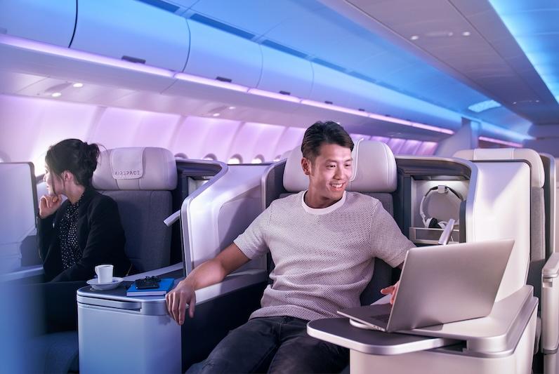 Man working on laptop in A330neo Airspace business class
