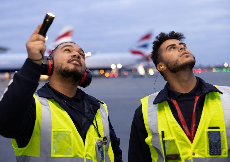 employees on tarmac with British Airways airplanes in the background