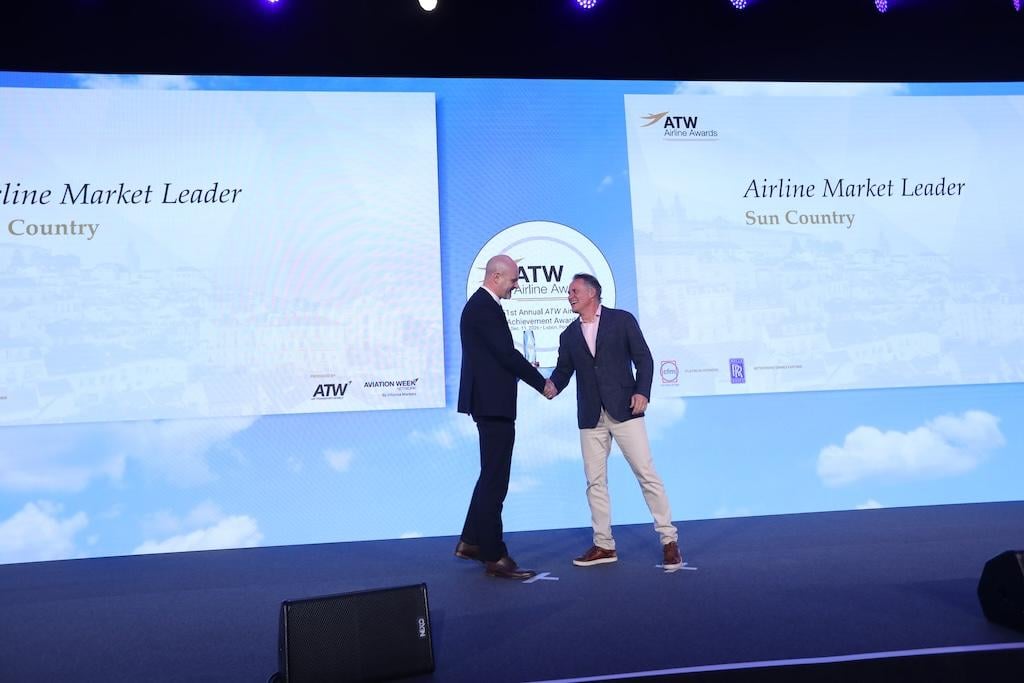 Routes editor-in-chief David Casey presents the Market Leader Award to Sun Country CEO Jude Bricker.