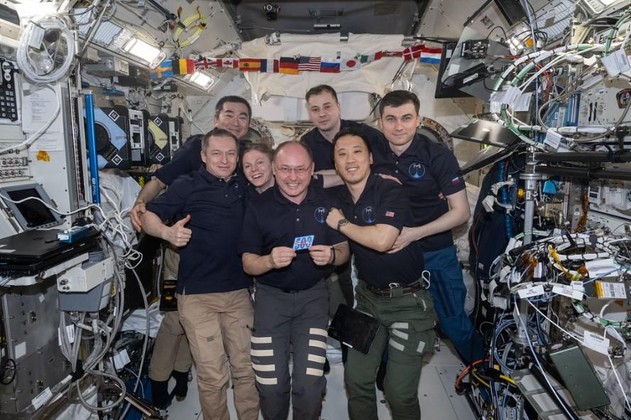 iss073e1198029 (Nov. 27, 2025) --- The seven-member Expedition 73 crew gathers together for a portrait inside the International Space Station's Kibo laboratory module celebrating NASA astronaut Mike Fincke's (center) 500 cumulative days in space over four missions since 2004. In the front from left are, Roscosmos cosmonaut Sergey Ryzhikov, NASA astronaut Zena Cardman, Mike Fincke, and NASA astronaut Jonny Kim. In the back are, JAXA (Japan Aerospace Exploration Agency) astronaut Kimiya Yui and Roscosmos cosm