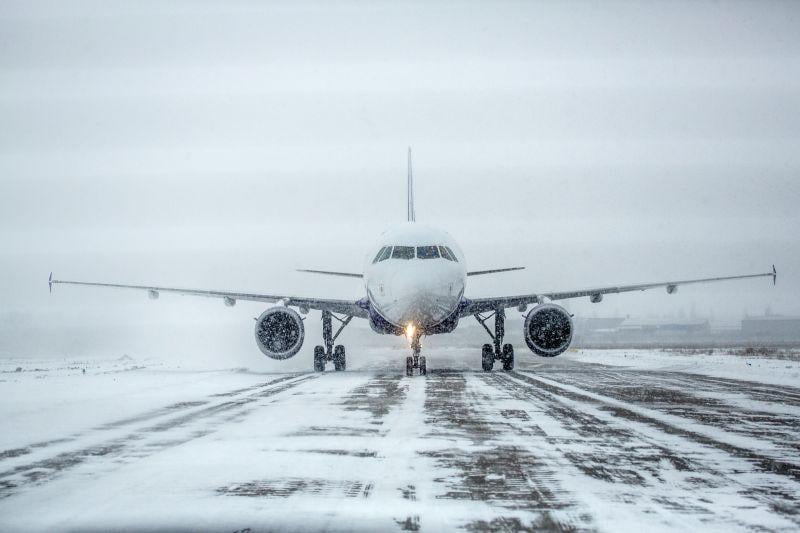 snow on an airplane and on runway