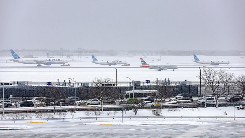 united and american aircraft lined up to take off snowy day chicago o'hare airport