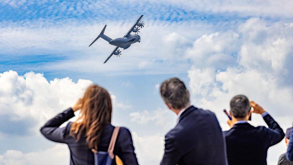 People looking at an airplane in the sky