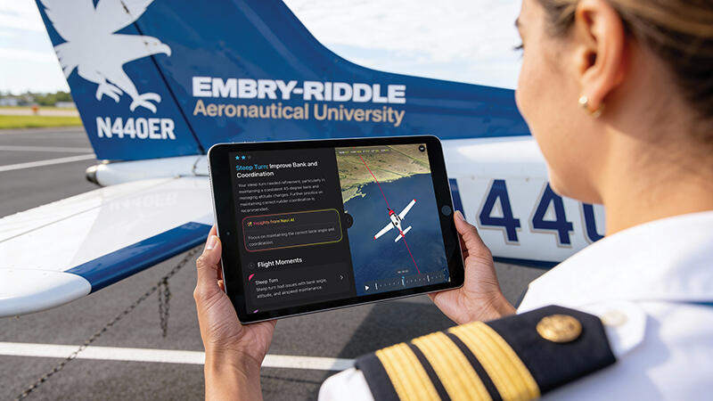 person looking at Navi on a tabletnext to an Embry-Riddle aircraft
