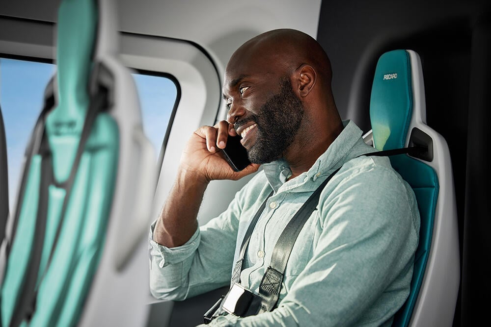 Man talking on phone inside Eve eVTOL