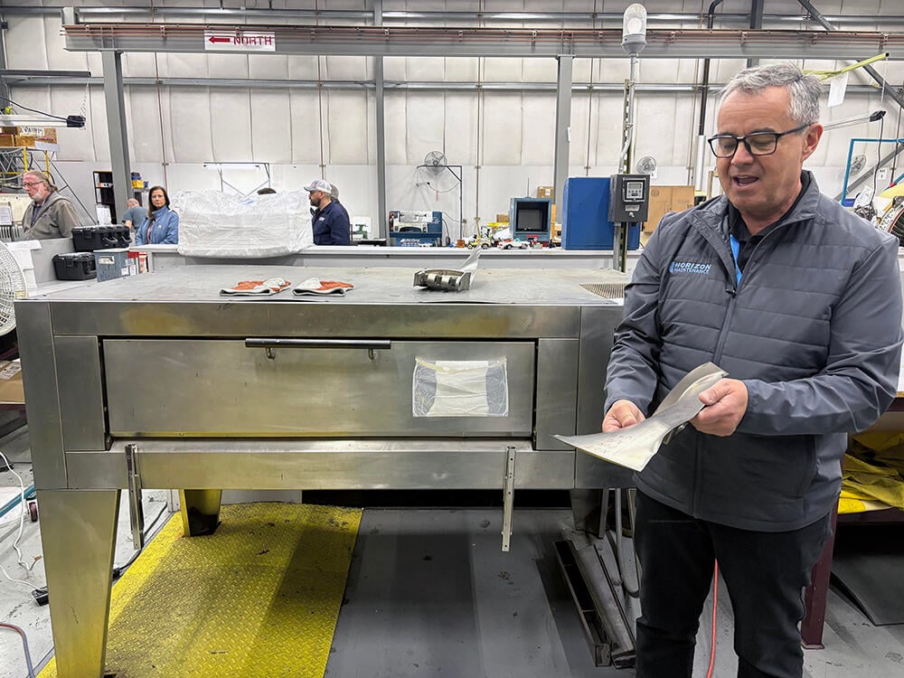 Archie Vega holding a blade in the engine shop