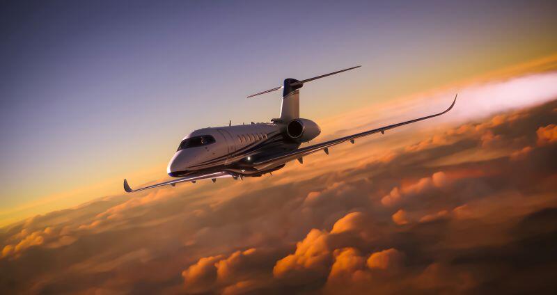 Business jet flying above clouds in the sunset