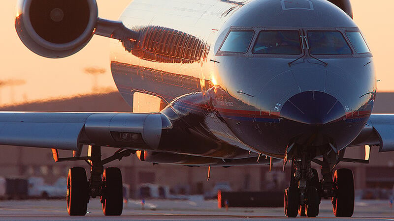 CRJ aircraft silhouetted against a light orange sky