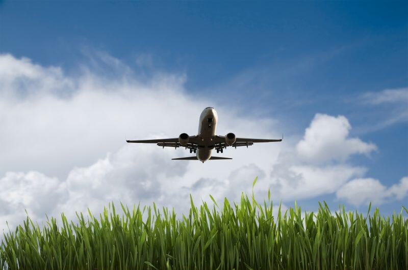 airplane flying over green grass