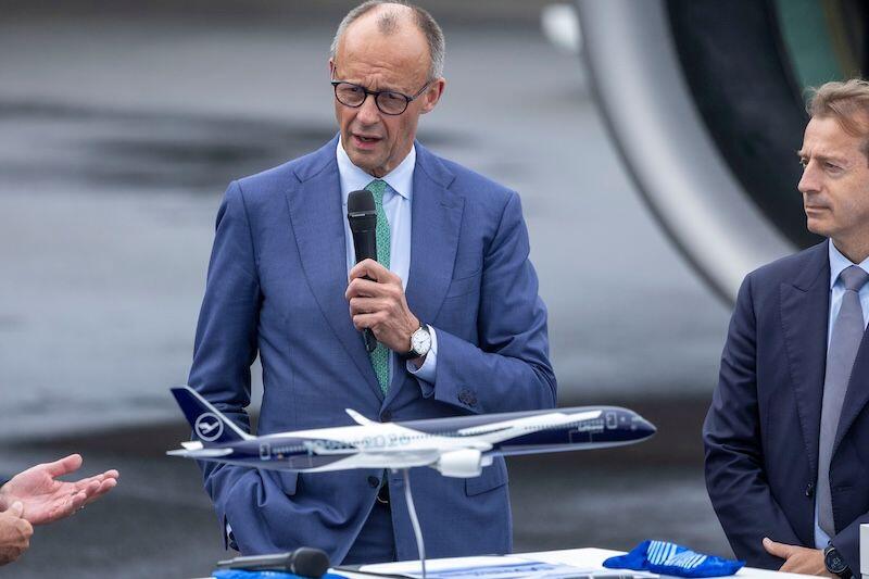 German Chancellor Friedrich Merz addresses ILA Berlin 2026 as Airbus CEO Guillaume Faury watches on.