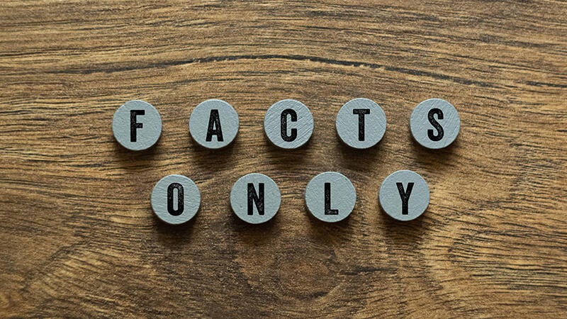 wooden circular tiles reading "facts only" 