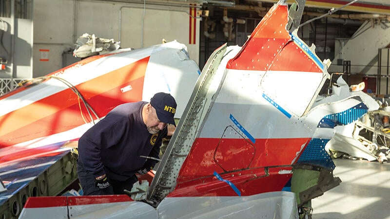 investigator studies aircraft wreckage