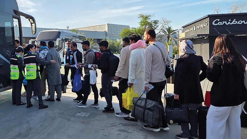 Passengers board coaches in Kuwait City 