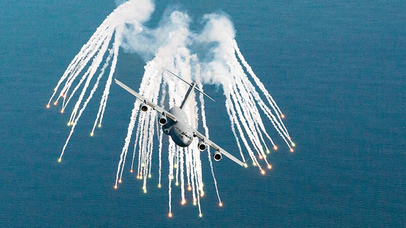 Boeing C-17 deploying flares over water