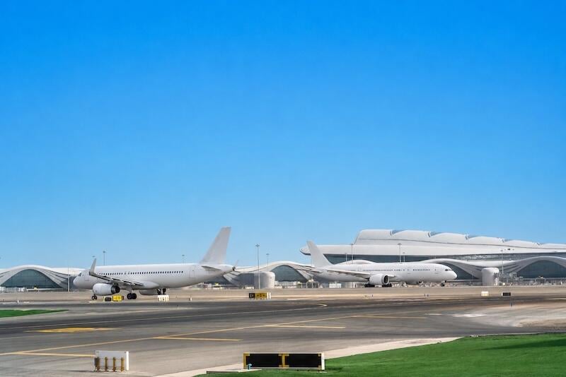 commercial aircraft sit on runway beside terminal