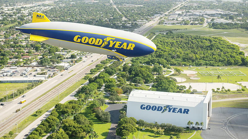 Goodyear blimp flying over highway
