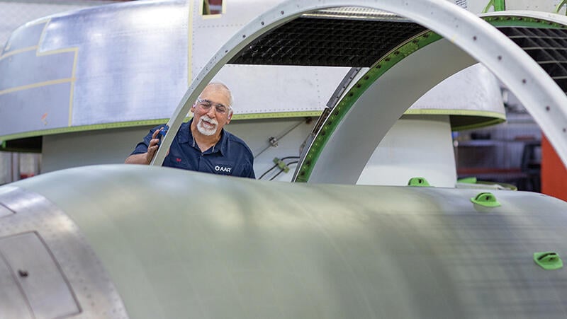 aviation maintenance technician working on a large aircraft engine nacelle