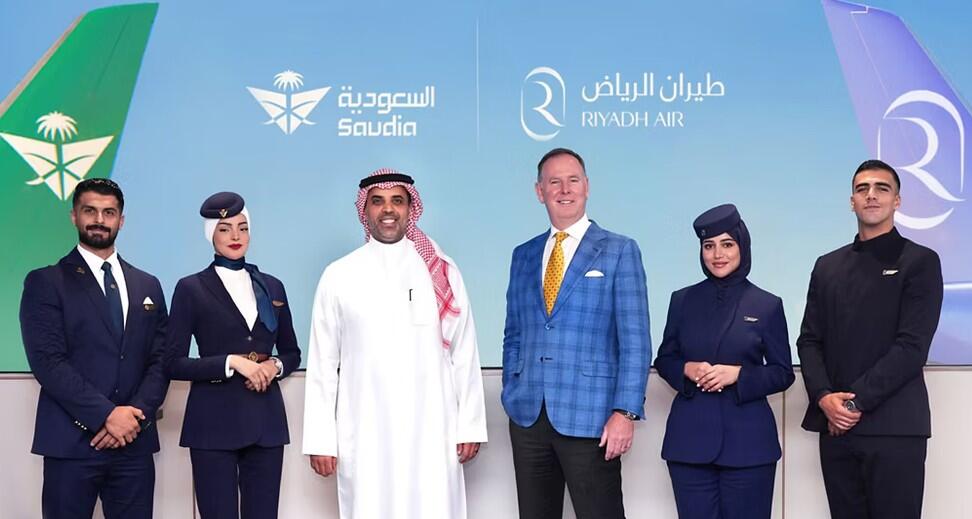 six people standing in front of screen showing Saudia and Riyadh Air logos and aircraft tails