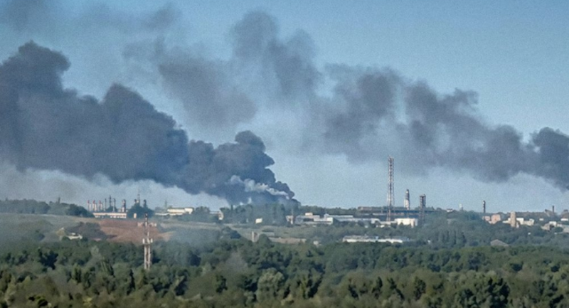 smoke billowing from oil refinery