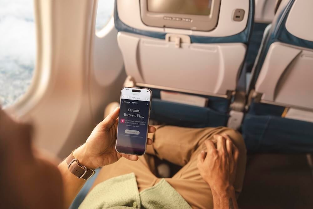 Hand holding smartphone with Alaska Airlines Starlink