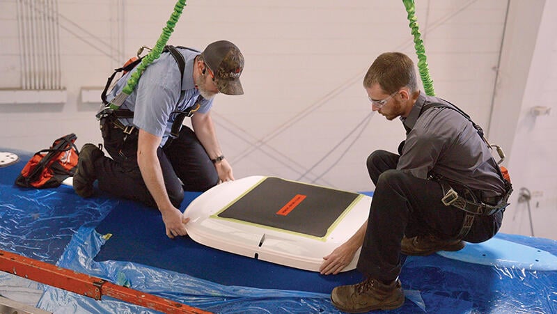 two people installing Starlink antenna on Bombardier Challenger 605