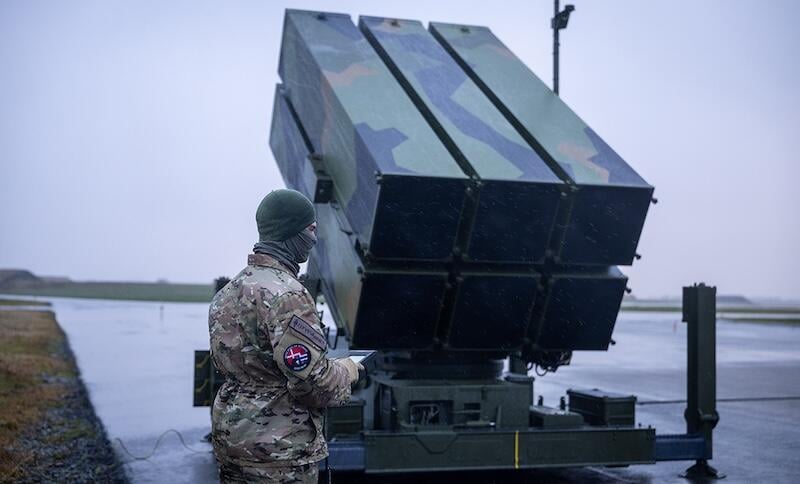 a military operator stands beside a nasams system