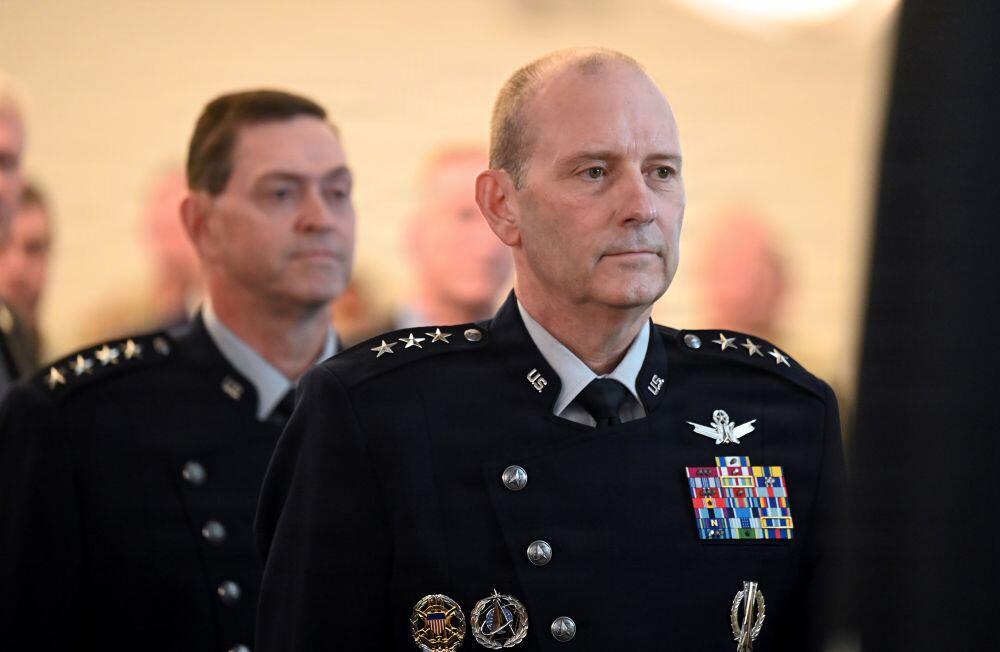 Lt. Gen. Douglas Schiess faces the American Flag as the National Anthem is played during his promotion ceremony, Joint Base Andrews Md., Sept. 3, 2026. Chief of Space Operations Gen. Chance Saltzman (background) hosted the event and promoted him to the rank of General. (U.S. Air Force photo by Andy Morataya)