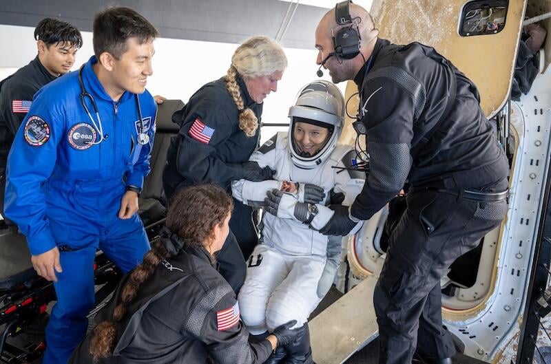 ESA astronaut sophie adenot helped out of spacecraft after splashdown