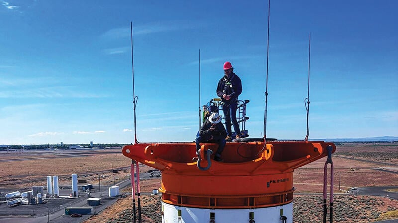 two people standing on top of rocket