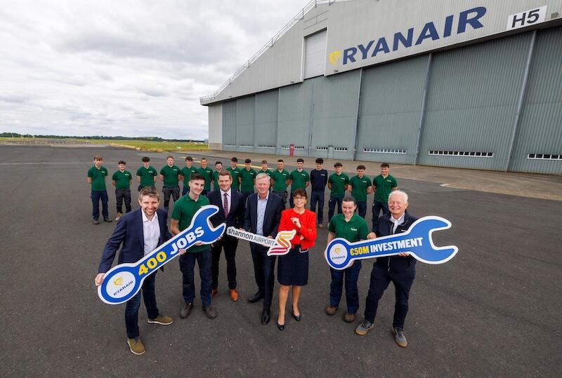 ryanair executives and staff pose outside an aircraft hangar