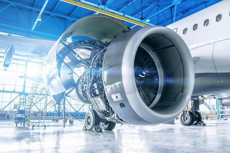 commercial aircraft engine exposed for maintenance inside hangar