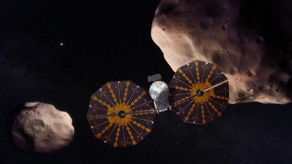 An illustration of the Lucy spacecraft flying by two of its asteroid targets. NASA/GSFC