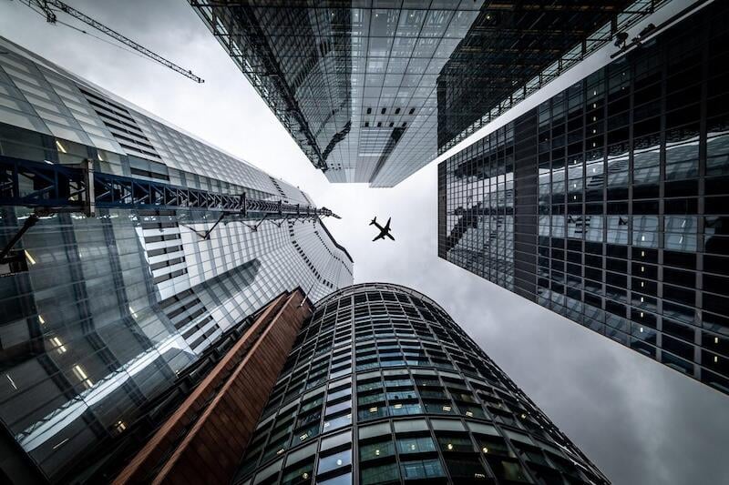 Tall buildings and an airliner overflying them