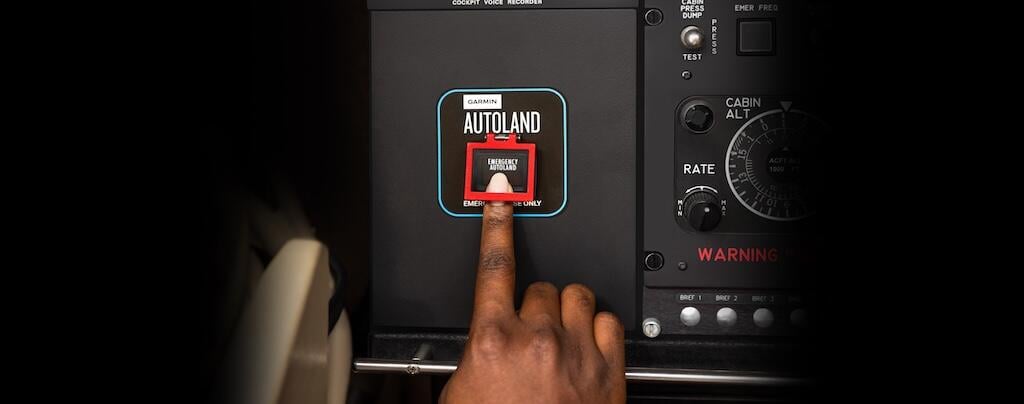 finger pressing autoland button