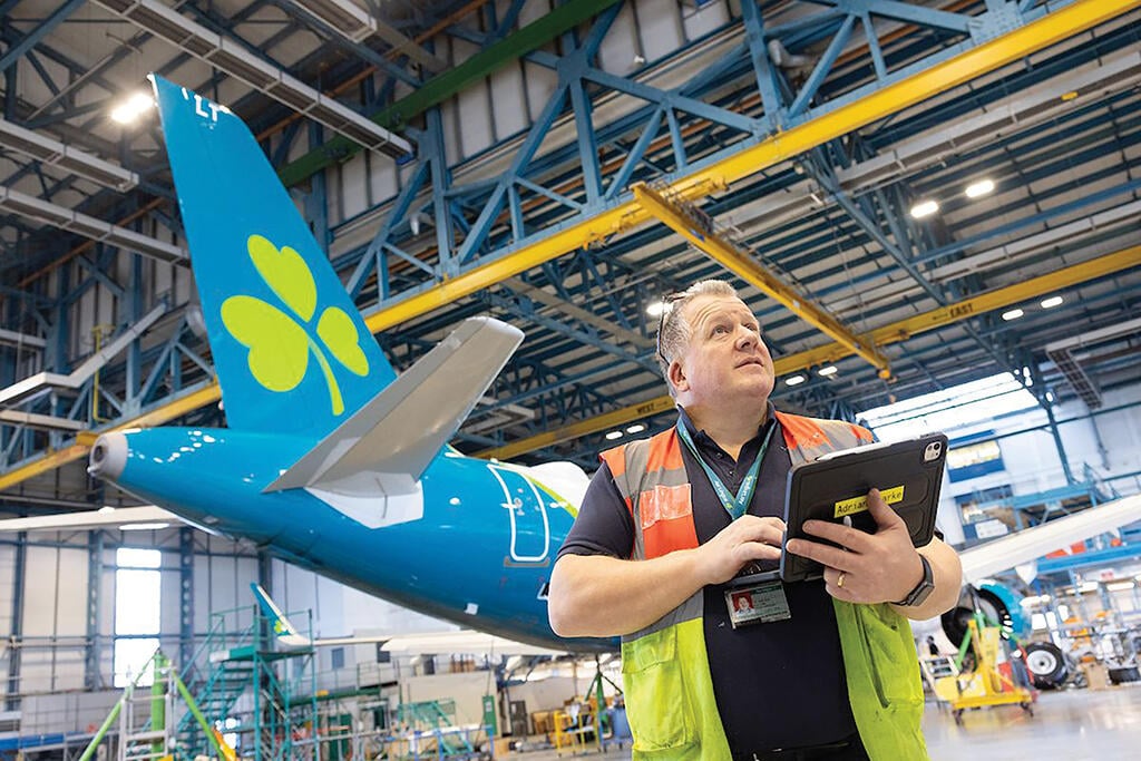 person holding graphics tablet by Aer Lingus jet