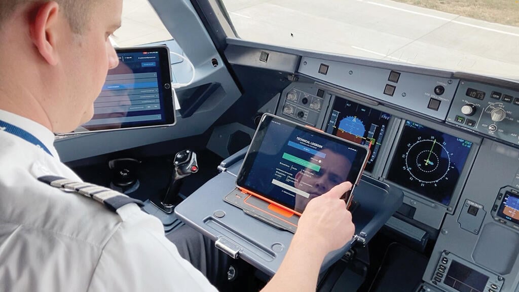 pilot in cockpit looking at tablet